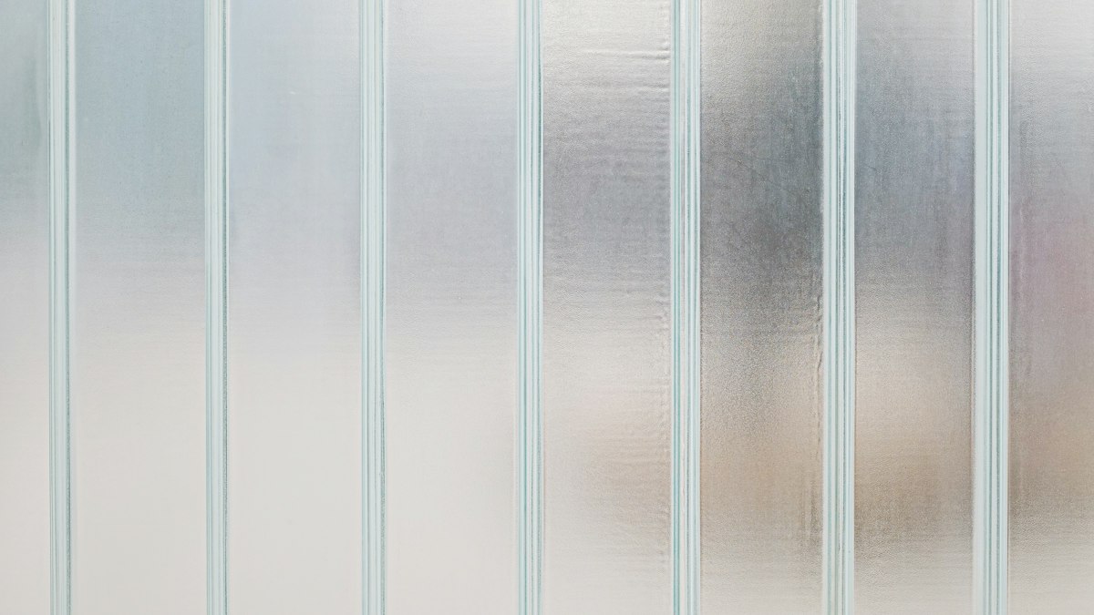Vertical panels of frosted glass with soft, blurred shapes visible behind them
