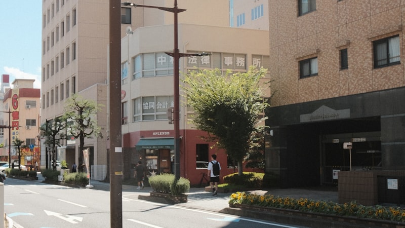 Japanese street sign with arrows and text on a city street